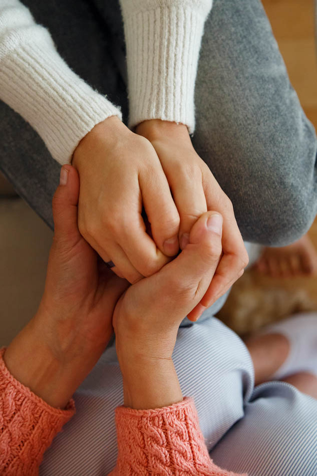 Liebevolles, begleitendes Händehalten einer Frau mit Eierstockkrebs